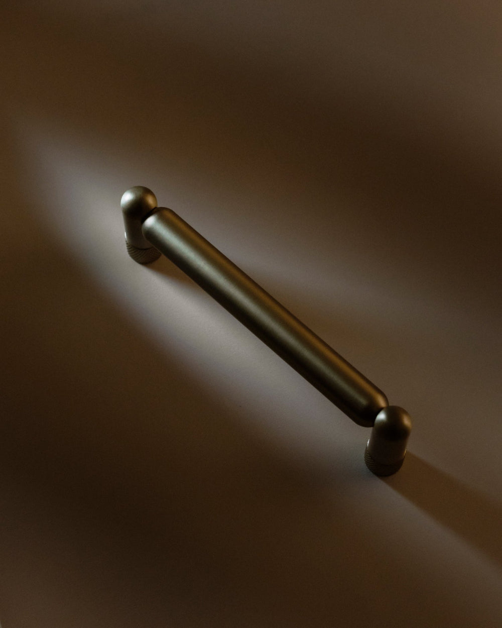 Knurled cabinet pull in graphite-modern handles in gray, brass, and brown tones
