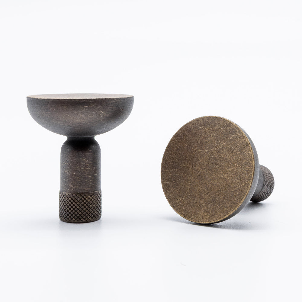 Knurled knob in dark aged brass with smooth round top and bar cut stem