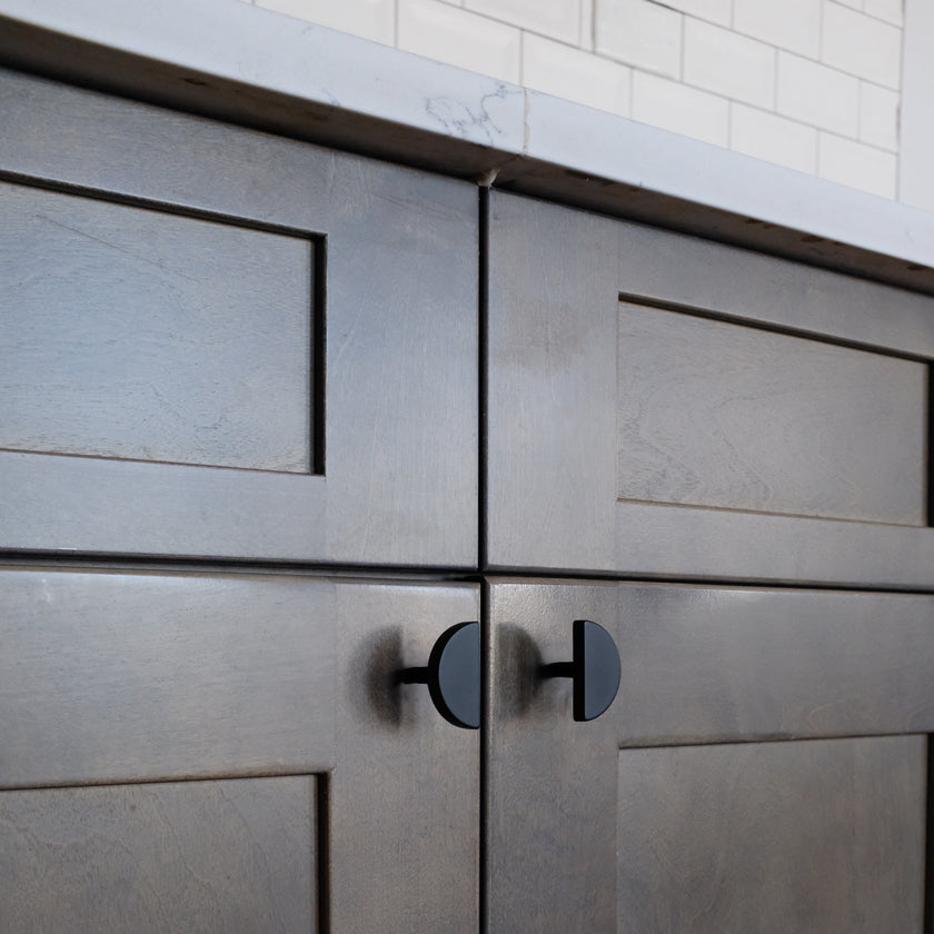 Half moon cabinet knobs in matte black for modern kitchen doors in contemporary homes