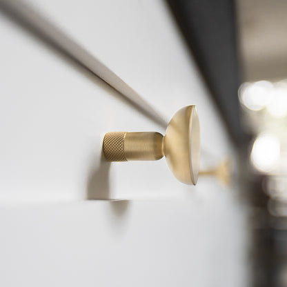Knurled round knob in satin brass with faceted modern etching for style