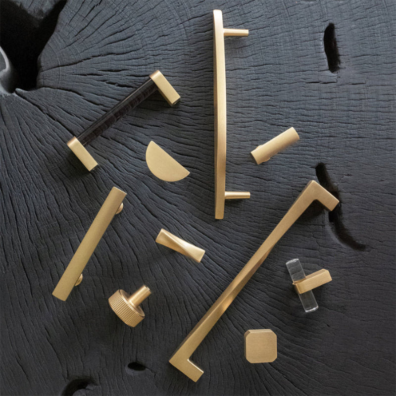 Satin brass cabinet pulls and knobs - modern hardware with gold tones on dark grey surface