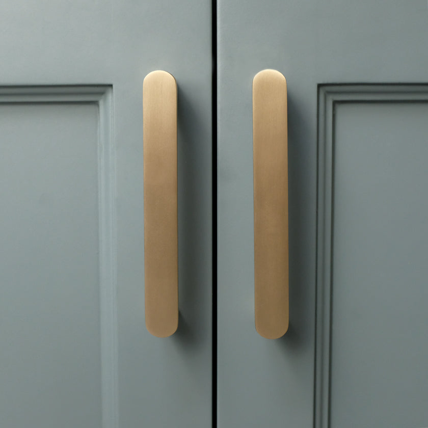 Ribbed pull in satin brass for contemporary cabinets in teal and nickel tones