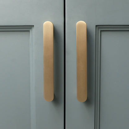 Ribbed pull in satin brass for contemporary cabinets in teal and nickel tones